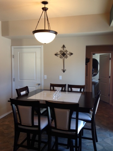 A dining room with a table and chairs.