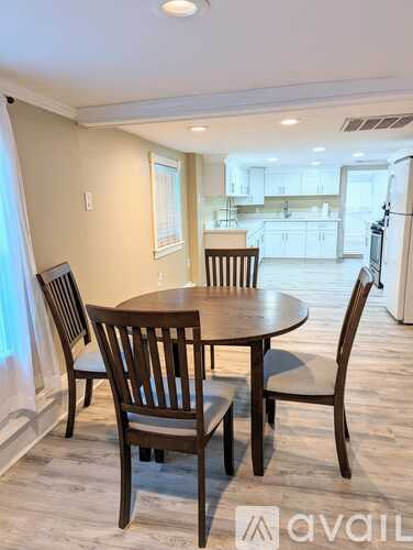 A dining room with a table and chairs.