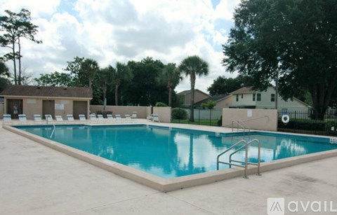 A swimming pool surrounded by a concrete floor and a metal fence.