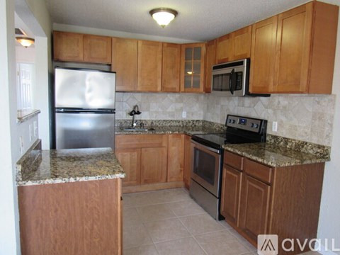 A kitchen with wooden cabinets and granite countertops.