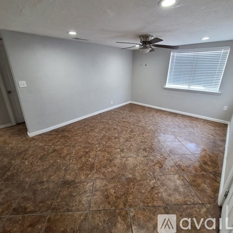 A room with a ceiling fan and tiled floor.