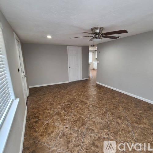A room with a ceiling fan and tiled flooring.