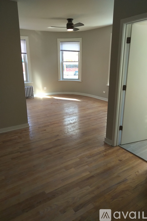A room with wooden floors and a ceiling fan.