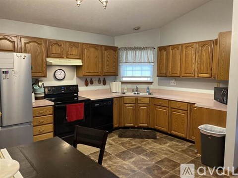 A kitchen with wooden cabinets and a black stove top oven.