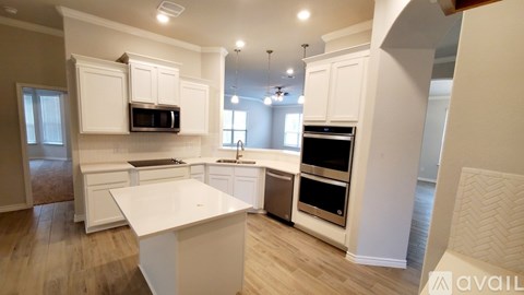 A kitchen with white cabinets and appliances is available for rent.