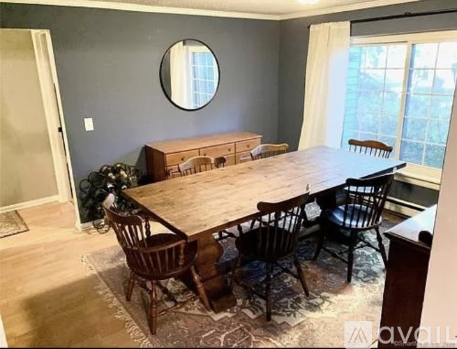 A dining room with a wooden table and chairs.