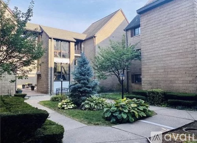 A modern building with a landscaped courtyard in front.
