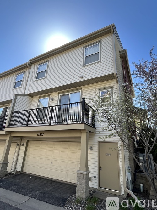 A two-story building with a balcony and garage.
