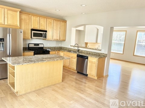 A kitchen with wooden cabinets and granite countertops.