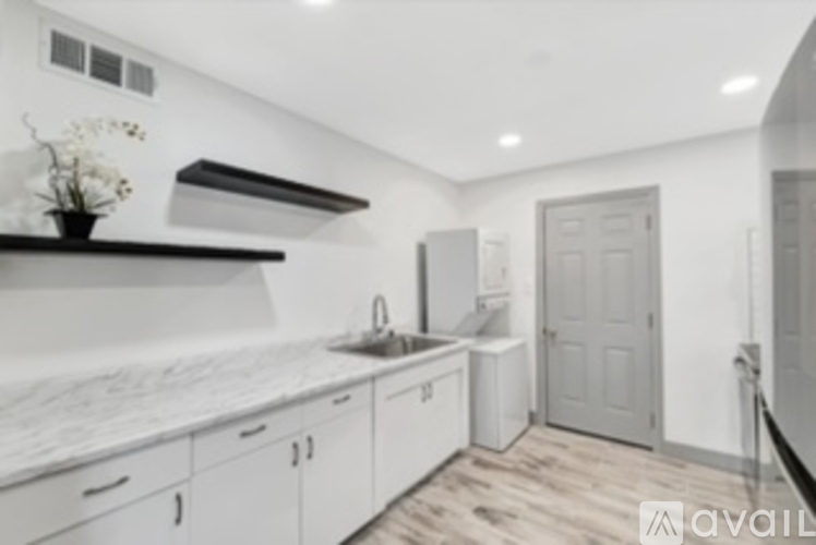 A kitchen with white cabinets and a marble countertop.