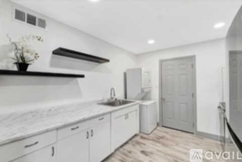 A kitchen with white cabinets and a marble countertop.