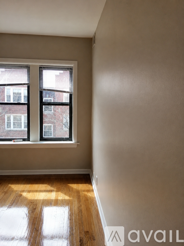 A room with a window and wooden flooring.
