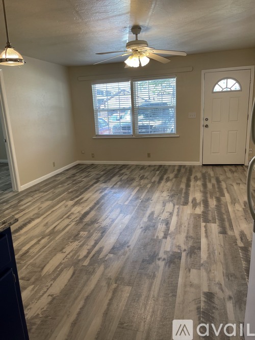 A room with a wooden floor and a ceiling fan.