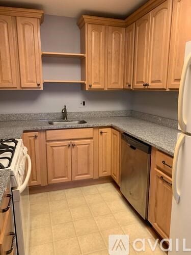 A kitchen with wooden cabinets and a white refrigerator.