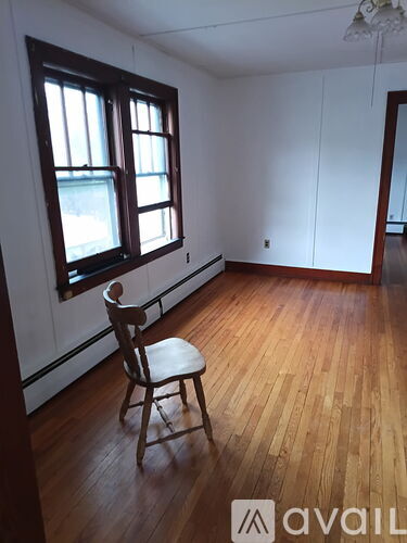 A room with a wooden floor and a chair.
