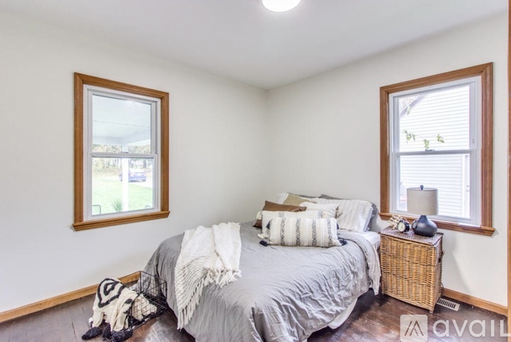 A bedroom with a bed, nightstand, and window.