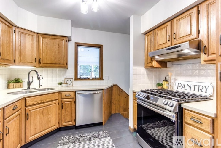 A kitchen with wooden cabinets and a pantry sign.