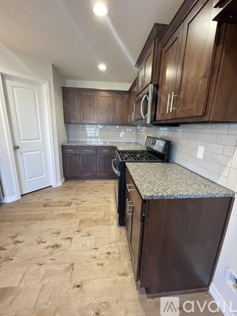A kitchen with wooden cabinets and a granite countertop.