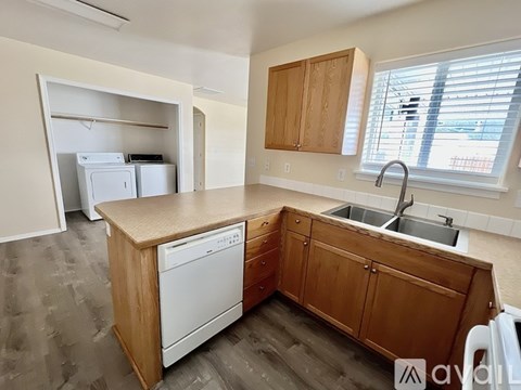 A kitchen with wooden cabinets and a white dishwasher.