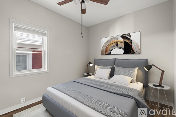 A bedroom with a large bed and a ceiling fan.