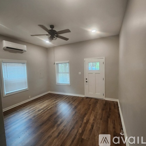 A room with a ceiling fan and wooden flooring.