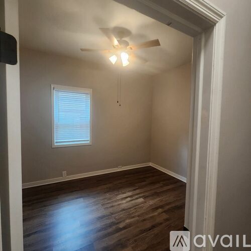 A room with wooden floors and a ceiling fan.