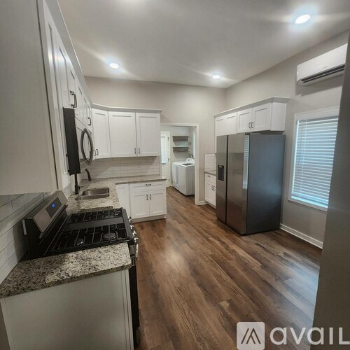A kitchen with white cabinets and a granite countertop.