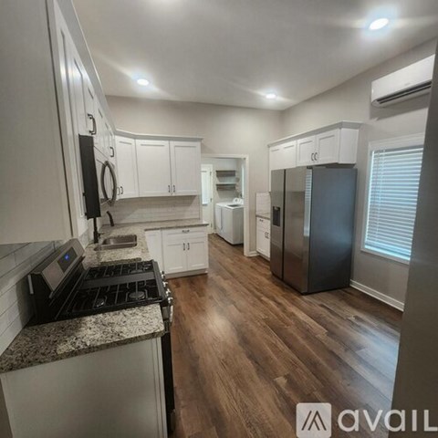 A kitchen with white cabinets and a granite countertop.