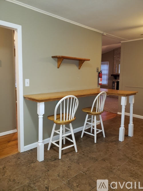 A dining room with a table and chairs.