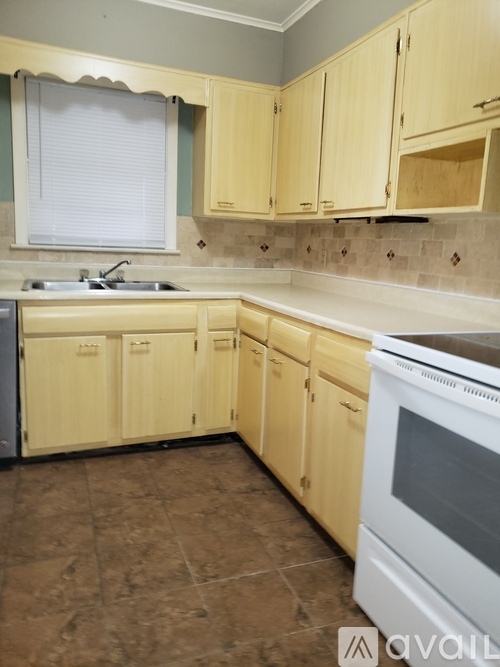 A kitchen with wooden cabinets and a white oven.
