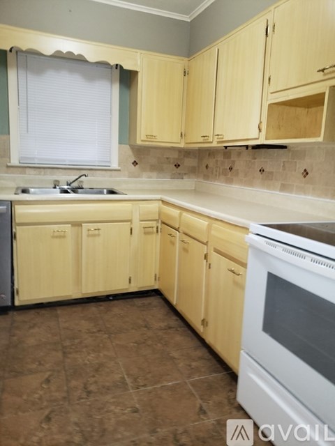 A kitchen with wooden cabinets and a white oven.