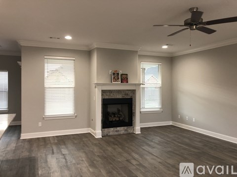 A living room with a fireplace and a ceiling fan.