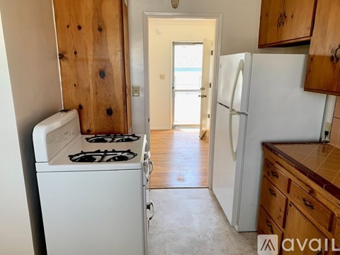 A kitchen with a white stove and a white refrigerator.