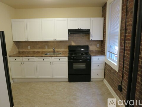 A kitchen with white cabinets and a black stove top oven.