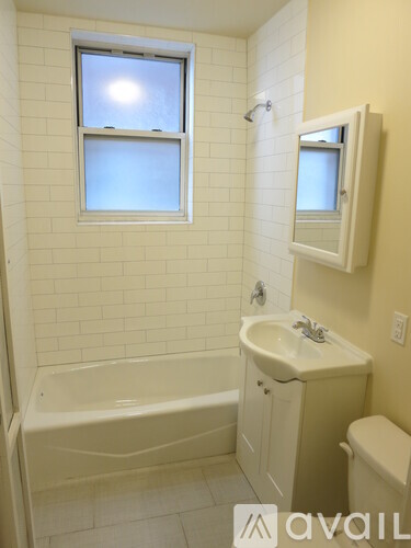 A bathroom with a tub, toilet, and sink.