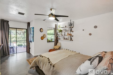 A bedroom with a large bed and a ceiling fan.