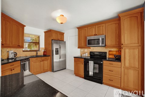 A kitchen with wooden cabinets and black appliances.