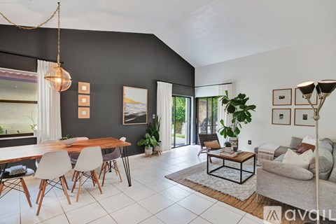 A modern living room with a dining table and chairs.