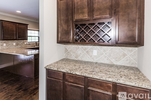 A kitchen with brown cabinets and a marble countertop.