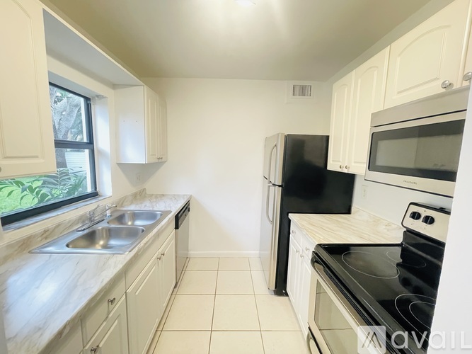 A kitchen with black appliances and white cabinets.