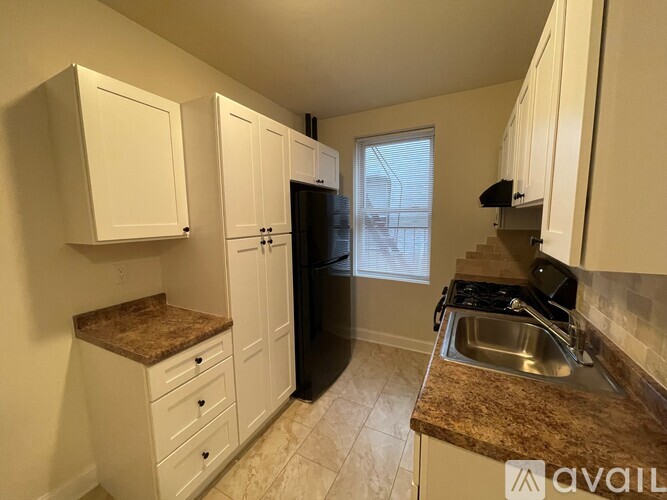 A kitchen with white cabinets and a granite countertop.