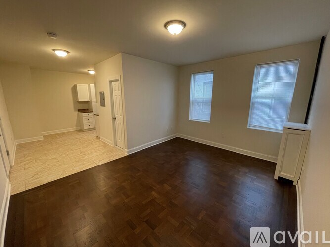 A room with wooden flooring and a window with blinds.