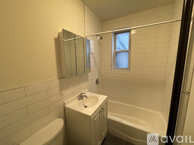 A bathroom with a white sink, tub, and toilet.