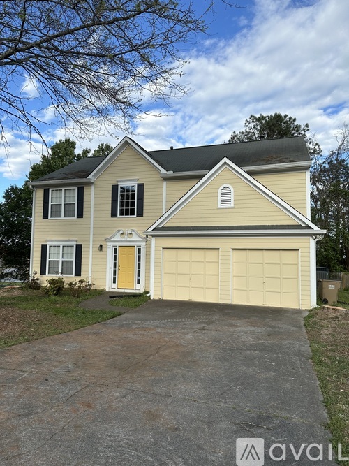 A two-story house with a garage and a driveway.