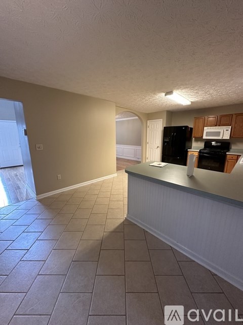 A kitchen area with a black refrigerator and stove.