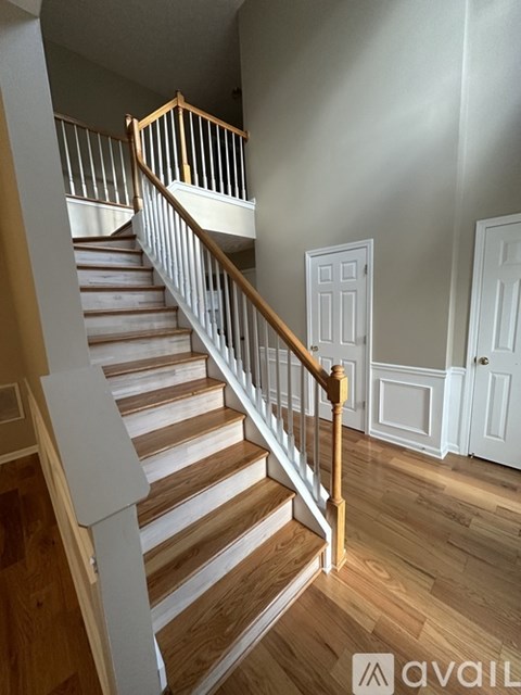 A wooden staircase with a white railing.