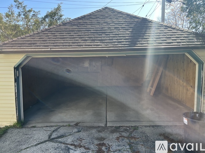 A garage with a wooden door and a concrete floor.