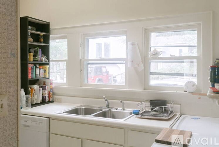 A kitchen with a white sink and a window.