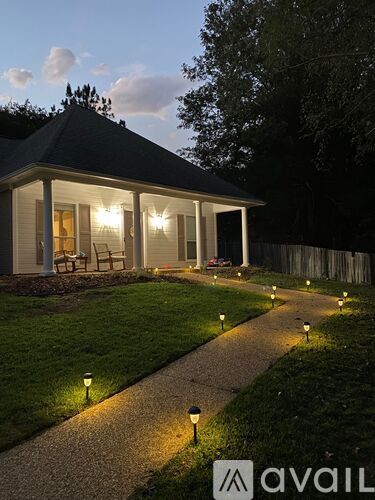 A house with a garden and lights on the ground.