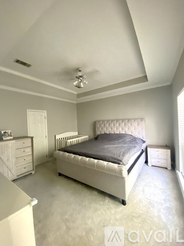 A bedroom with a bed, dresser, and nightstand.